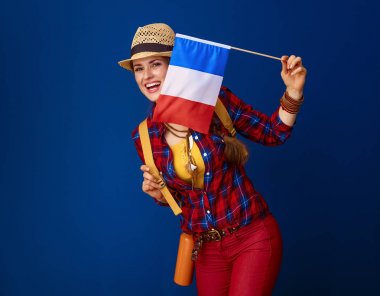 gülümseyen turist kadın Fransa bayrağı mavi arka plan karşı gösterilen sırt çantası ile uygun