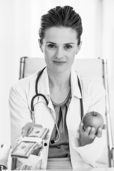 Medico Donna Mostrando Mela Pacchetto Soldi — Foto Stock