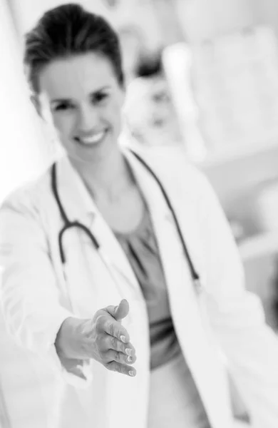 笑って握手を求めて手を伸ばすのオフィスで医師の女性へのクローズ アップ — ストック写真