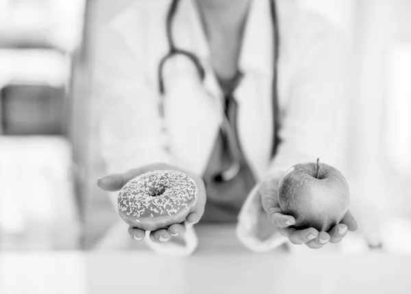 Close Médico Mulher Dando Uma Escolha Entre Maçã Donut — Fotografia de Stock