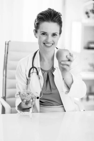 Feliz Médico Mujer Dando Manzana Lugar Donut — Foto de Stock