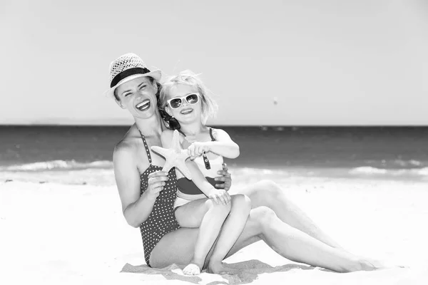 Sonriente Joven Madre Hijo Traje Baño Playa Mostrando Estrellas Mar — Foto de Stock