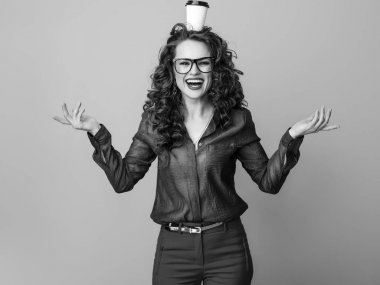 gülümseyen kafasına bir fincan kahve ile uzun dalgalı esmer saçlı modern kadın