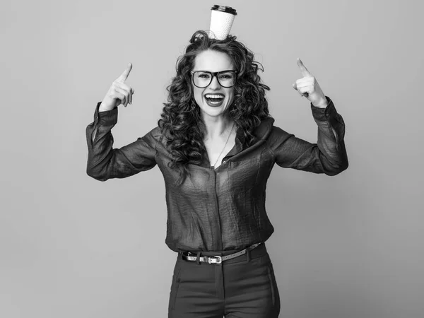 頭の上のコーヒー カップを指して長い波状のブルネットの髪を持つ幸せな若い女性 — ストック写真
