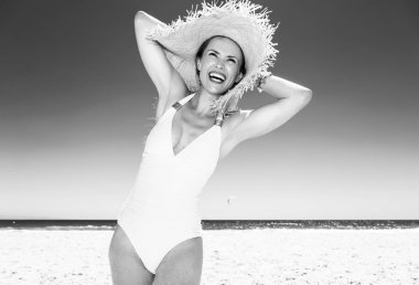 Beyaz kum eğlenceye. Mayo mesafe içine arayan sahil üzerinde gülümseyen modern kadın portresi