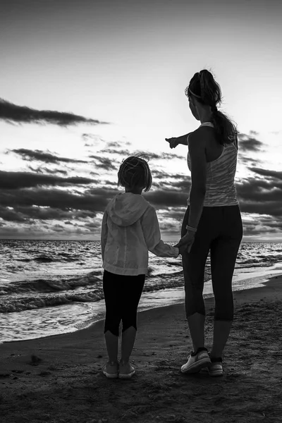 Healthy Mother Child Sport Style Clothes Seashore Sunset Pointing Something — Stock Photo, Image