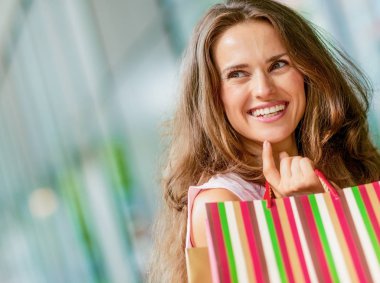 Alışveriş torbalarıyla mutlu genç bir kadın.