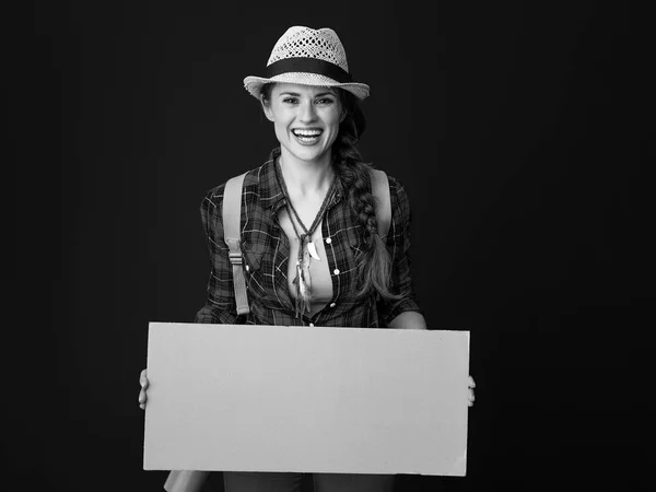 空白のボードを示す格子縞のシャツで幸せな健康な女性ハイカー — ストック写真