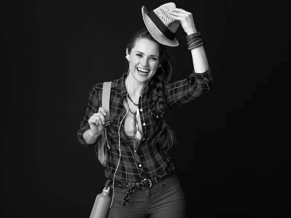 バックパックと帽子を上昇音楽を聴くヘッドフォン女性と幸せなフィット観光 — ストック写真