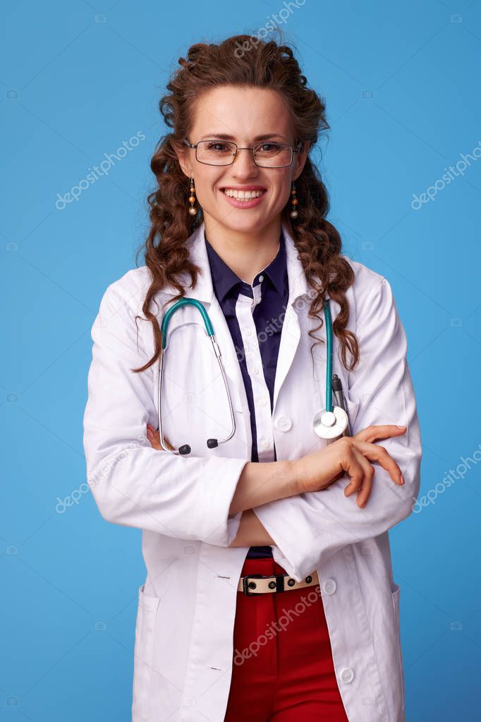 happy medical practitioner woman in white medical robe on blue background
