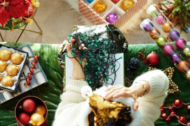 Mutsuz moda kadın karışık Noel ışıkları tutuyor.