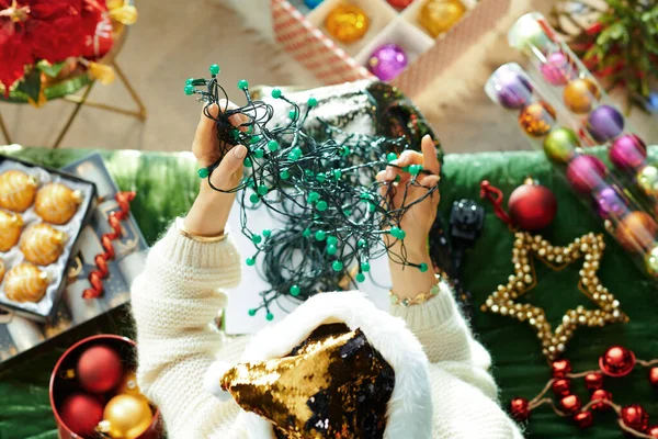 Mulher elegante tentando desembaraçar emaranhado luzes de Natal — Fotografia de Stock