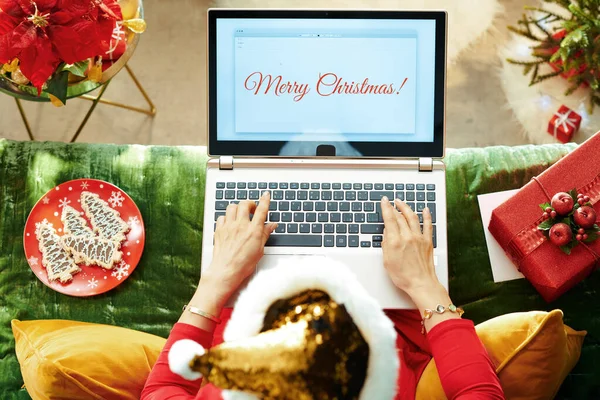 Гарна жінка пише різдвяну пошту на ноутбуку. — стокове фото