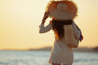stylish woman on beach at sunset walking clipart
