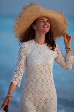 Kadın gün batımında okyanus kıyısında stres boş zamanlarının tadını çıkarıyor.