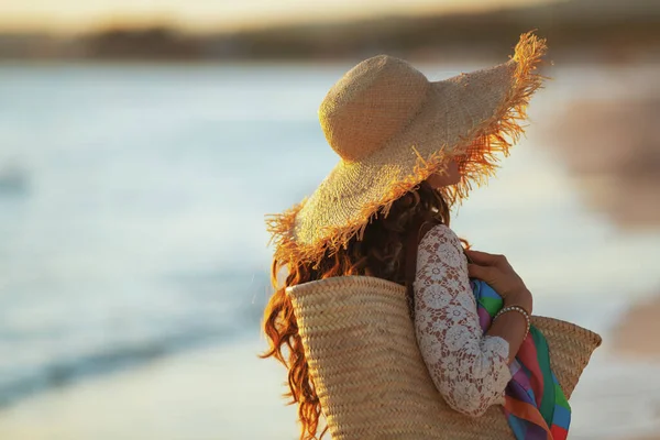 Ung kvinna på stranden vid solnedgången promenader — Stockfoto