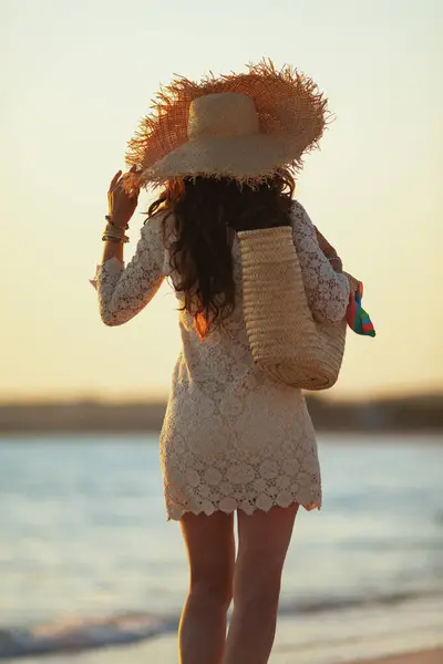 Mulher moderna de meia-idade na praia ao pôr do sol andando — Fotografia de Stock