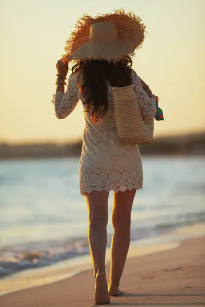 Jovem mulher no litoral ao pôr do sol andando — Fotografia de Stock