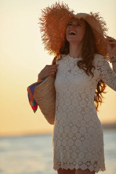 Donna sorridente sulla spiaggia al tramonto divertendosi — Foto Stock