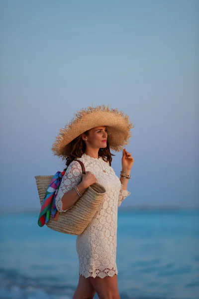 Relajado elegante mujer de 40 años en la playa al atardecer —  Fotos de Stock