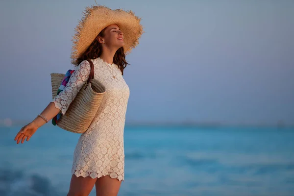 Heureuse femme de 40 ans sur le littoral au coucher du soleil se réjouissant — Photo