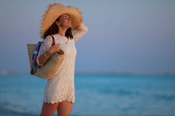 Szczęśliwa kobieta na plaży o zachodzie słońca ciesząca się spokojnym środowiskiem — Zdjęcie stockowe