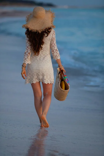 Gün batımında sahilde yürüyen 40 yaşında bir kadın. — Stok fotoğraf