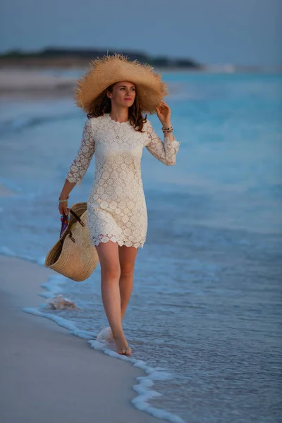 Mujer elegante relajado en la costa al atardecer caminando —  Fotos de Stock