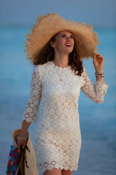 Mujer en la orilla del mar al atardecer disfrutando de un ambiente calmante —  Fotos de Stock