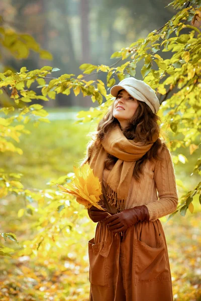 Moderne Frau mit gelben Blättern, die zum Kopierraum aufschaut — Stockfoto