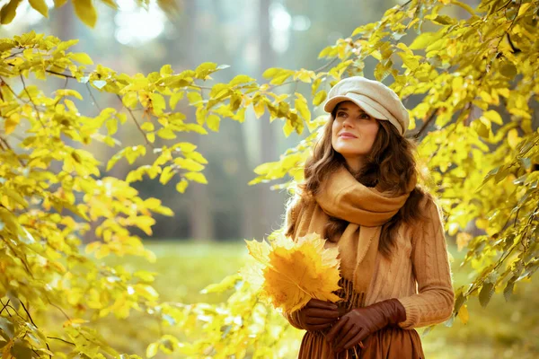 Ευτυχισμένη νεαρή γυναίκα με κίτρινα φύλλα κοιτάζει ψηλά στο χώρο αντίγραφο — Φωτογραφία Αρχείου