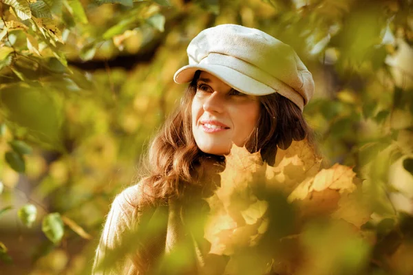 Žena se žlutými listy venku v podzimním parku mezi listy — Stock fotografie
