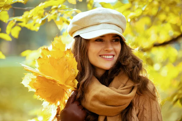 Frau mit gelben Blättern draußen im Herbstpark inmitten von Laub — Stockfoto