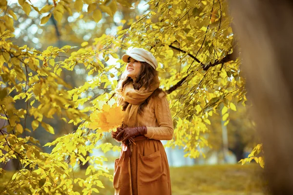 Ευτυχισμένη μοντέρνα γυναίκα με κίτρινα φύλλα κοιτάζοντας ψηλά στο χώρο αντίγραφο — Φωτογραφία Αρχείου