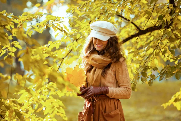 Femme avec des feuilles jaunes à l'extérieur dans le parc d'automne parmi le feuillage — Photo