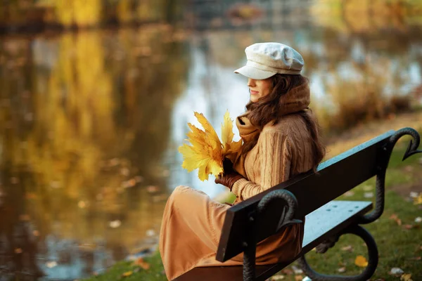 Nachdenkliche Trendfrau mit gelben Blättern — Stockfoto
