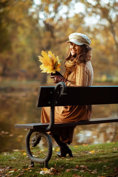 Szczęśliwa stylowa kobieta z żółtymi liśćmi — Zdjęcie stockowe