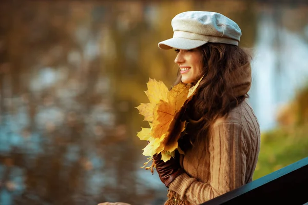 Sourire élégant femme âgée de 40 ans avec des feuilles jaunes — Photo