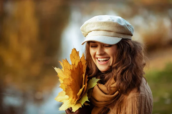 Lächelnde Trendfrau mit gelben Blättern genießt die Herbstzeit — Stockfoto