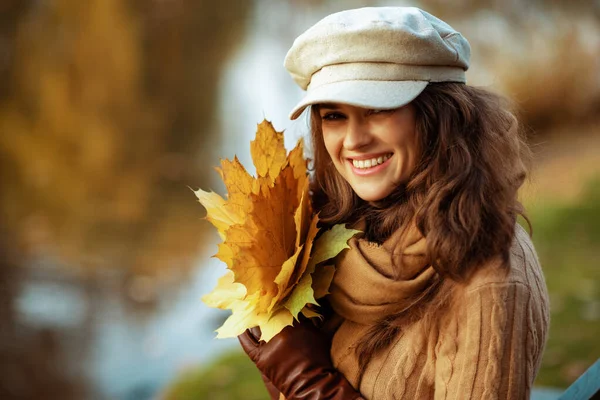 Mulher moderna sorridente com folhas amarelas — Fotografia de Stock