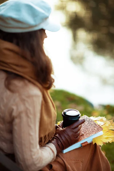 Mulher com caderno, xícara de café e folhas amarelas — Fotografia de Stock