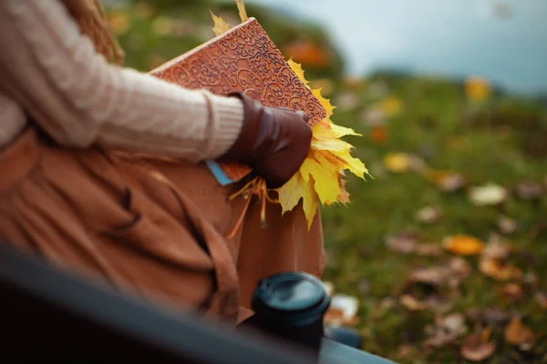 Gros plan sur la femme avec cahier, feuilles jaunes et tasse de café — Photo