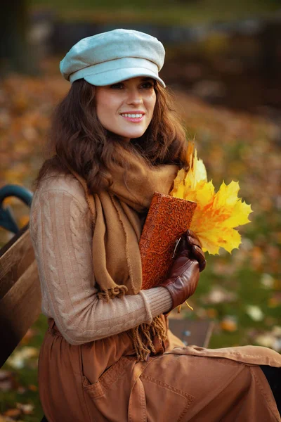Gelukkig trendy vrouw met notebook en gele bladeren — Stockfoto