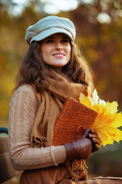 Mulher da moda feliz com caderno e folhas amarelas — Fotografia de Stock