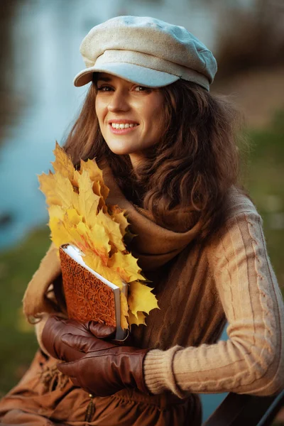 快乐的现代40岁女人，带着笔记本和黄色的叶子 — 图库照片
