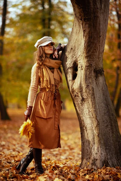 Donna pensosa con foglie gialle all'aperto nel parco autunnale — Foto Stock