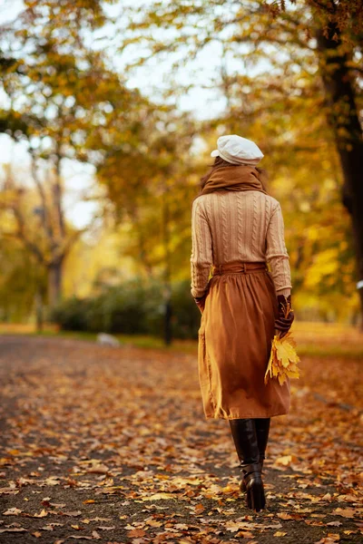 Mulher na moda com folhas amarelas andando fora no parque de outono — Fotografia de Stock