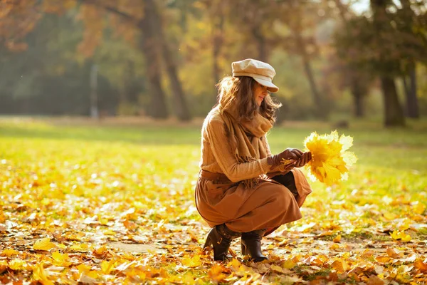 Mujer elegante al aire libre en otoño parque reuniendo hojas — Foto de Stock