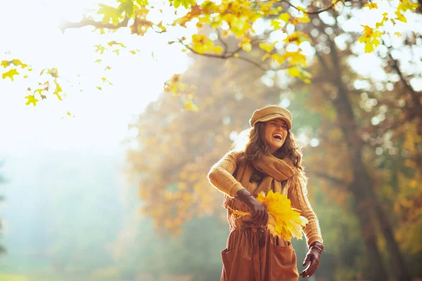 Mulher com folhas amarelas se divertindo fora no parque de outono — Fotografia de Stock