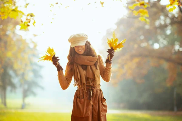 Femme moderne avec des feuilles jaunes à l'extérieur dans le parc d'automne — Photo